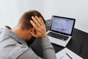 Stressed business owner at desk realizing costly mistakes